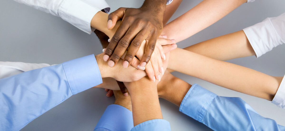 a group of people putting their hands together.