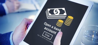 a person holding a tablet with a bank account on it.