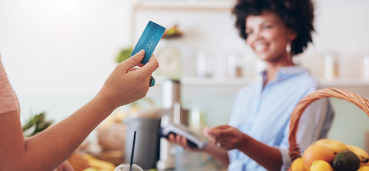 a woman holding a credit card in a kitchen.