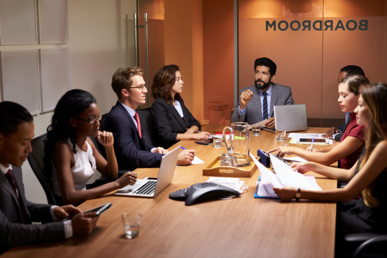 a group of people sitting around a conference table.