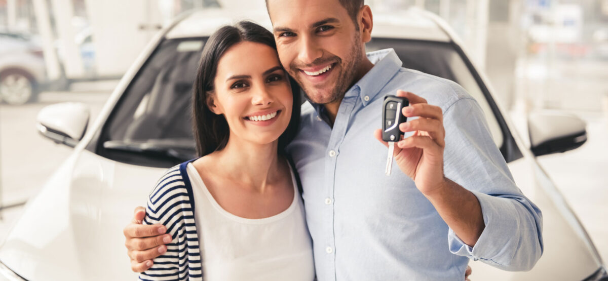 a man and a woman holding a car key.