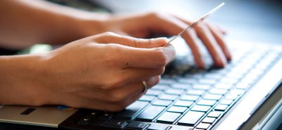 a person is typing on a laptop keyboard.